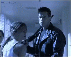 A Man In A Leather Jacket Is Holding A Woman 'S Neck In A Hallway With The Website 4Gifs.com Visible GIF
