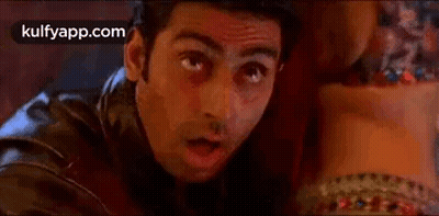 A Man In A Leather Jacket Is Looking At A Woman 'S Waist . GIF