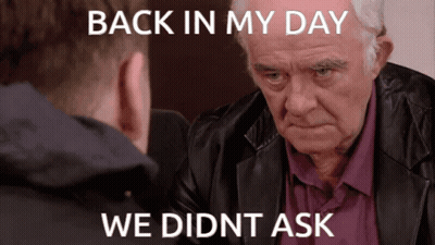 A Man In A Leather Jacket Is Looking At Another Man With The Caption Back In My Day We Didn T Ask GIF