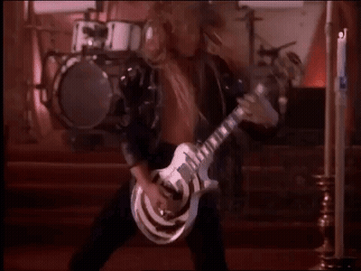 A Man In A Leather Jacket Is Playing A Guitar In A Church . GIF