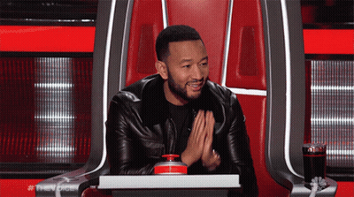 A Man In A Leather Jacket Is Sitting In A Chair With The Word The Voice On The Back GIF