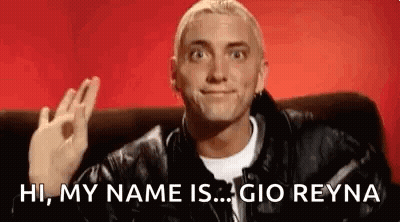 A Man In A Leather Jacket Is Sitting On A Couch And Making An Ok Sign . GIF