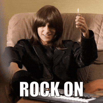 A Man In A Leather Jacket Is Sitting On A Couch Holding A Lighter And The Word Rock On Is On The Bottom GIF