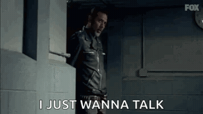 A Man In A Leather Jacket Is Standing In A Doorway And Talking . GIF