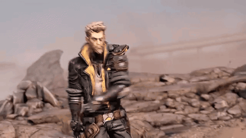 A Man In A Leather Jacket Is Standing In A Rocky Desert . GIF