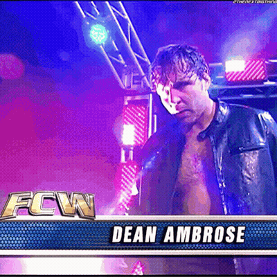 A Man In A Leather Jacket Is Standing In Front Of A Banner That Says Fcw Dean Ambrose GIF