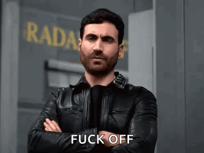 A Man In A Leather Jacket Is Standing In Front Of A Building With His Arms Crossed And Says Fuck Off . GIF