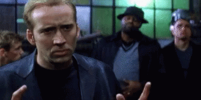 A Man In A Leather Jacket Is Standing In Front Of A Crowd Of People . GIF