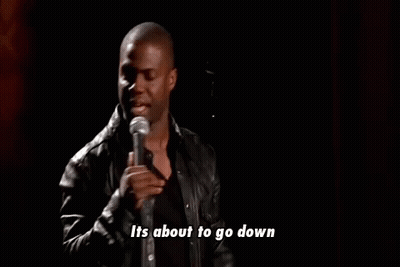 A Man In A Leather Jacket Is Standing In Front Of A Microphone And Talking Into It . GIF