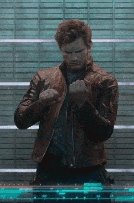 A Man In A Leather Jacket Is Standing In Front Of A Screen With Numbers On It . GIF