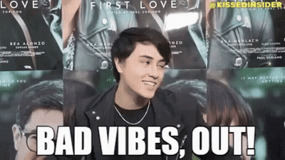 A Man In A Leather Jacket Is Standing In Front Of A Wall Of Posters For The Movie First Love . GIF