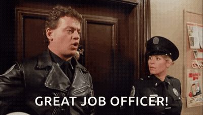A Man In A Leather Jacket Is Standing Next To A Woman In A Police Uniform And Says `` Great Job Officer '' . GIF