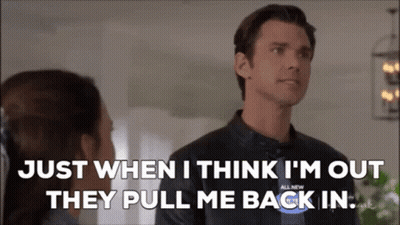 A Man In A Leather Jacket Is Talking To A Woman In A Living Room . GIF