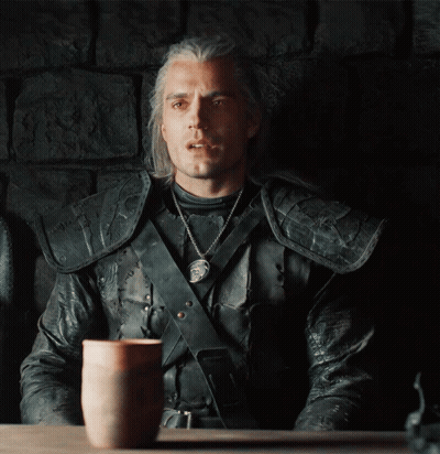 A Man In A Leather Jacket Sits At A Table With A Cup On It GIF