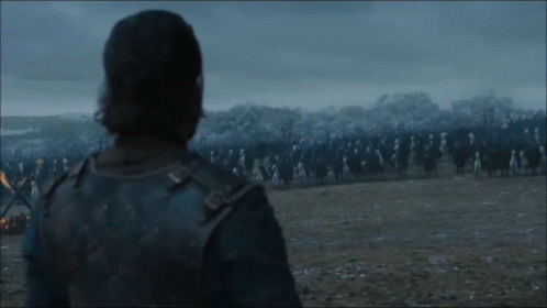 A Man In A Leather Jacket Stands In Front Of A Large Group Of Soldiers In A Field . GIF