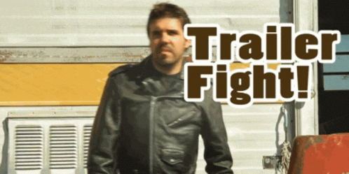 A Man In A Leather Jacket Stands In Front Of A Trailer That Says Trailer Fight On It GIF