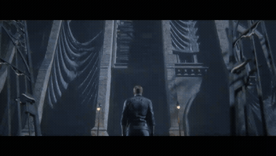 A Man In A Leather Jacket Stands In Front Of A Very Tall Building GIF
