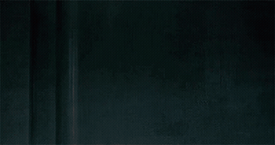 A Man In A Leather Jacket With A Bloody Face Is Standing Next To A Wall . GIF