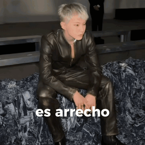A Man In A Leather Suit Is Sitting On A Pile Of Rocks With The Words Es Arrecho Written On The Bottom GIF