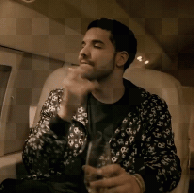 A Man In A Leopard Print Jacket Holds A Glass In His Hand GIF