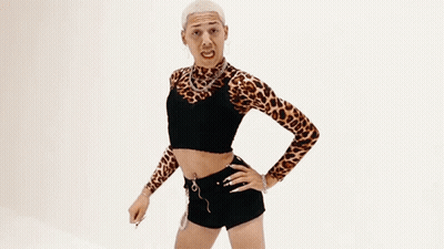A Man In A Leopard Print Top Is Flexing His Arm . GIF