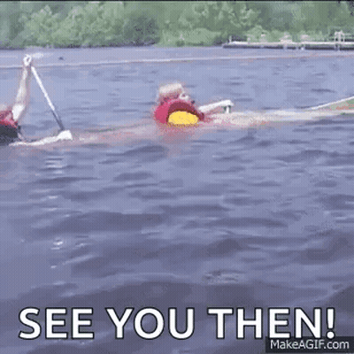 A Man In A Life Jacket Is Swimming In A Lake . GIF