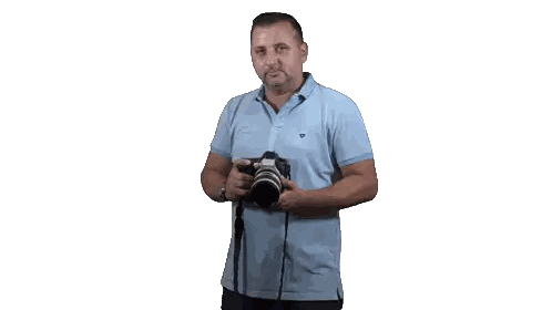 A Man In A Light Blue Polo Shirt Holds A Camera Sticker