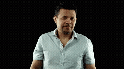 A Man In A Light Blue Shirt Is Making A Gesture With His Hands GIF