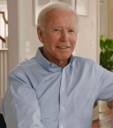 A Man In A Light Blue Shirt Is Smiling For The Camera GIF