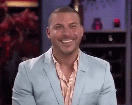 A Man In A Light Blue Suit Is Smiling . GIF