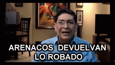 A Man In A Living Room With The Words Arenacos Devuelvan Lo Robado GIF