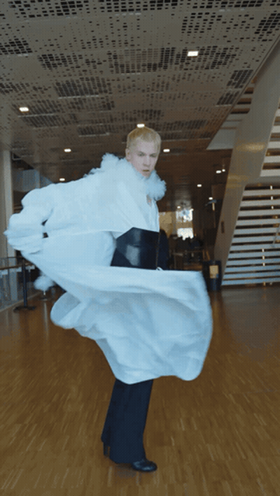 A Man In A Long White Coat And Black Pants Is Dancing GIF