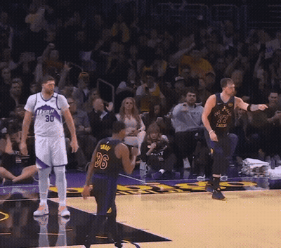 A Man In A Los Angeles Lakers Jersey Stands In Front Of A Crowd GIF
