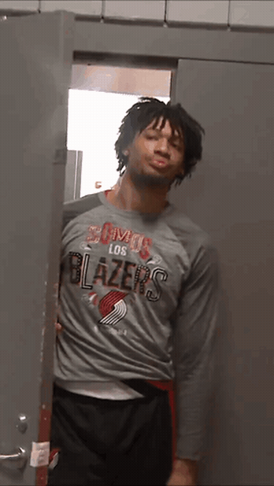 A Man In A Los Blazers Shirt Is Standing In A Doorway GIF