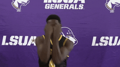A Man In A Lsua Jersey Smiles In Front Of A Purple Backdrop GIF