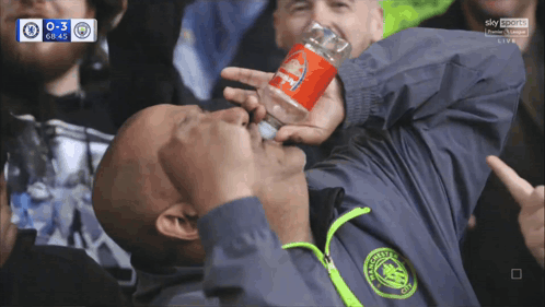 A Man In A Manchester City Jacket Drinks From A Coca Cola Can GIF