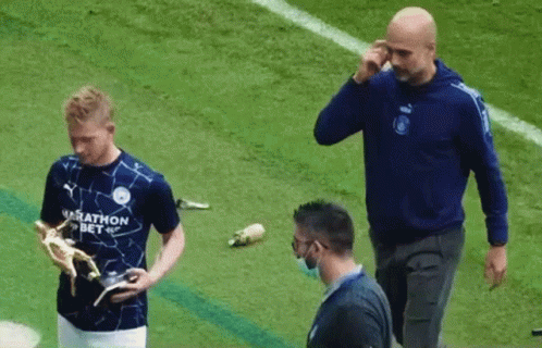 A Man In A Marathon Bet Shirt Holds A Trophy On A Soccer Field GIF