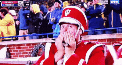 A Man In A Marching Band Uniform Covering His Face With His Hands GIF