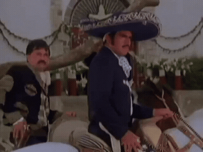 A Man In A Mariachi Outfit Is Riding A Horse . GIF