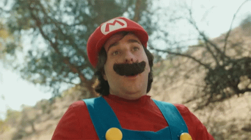 A Man In A Mario Costume With A Red Hat And Mustache GIF