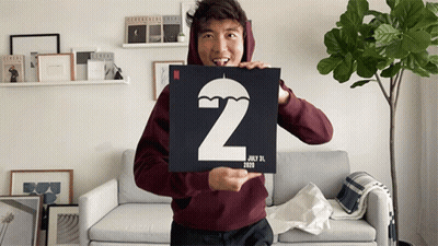 A Man In A Maroon Hoodie Is Holding A Sign With The Number 2 And The Date July 31 2020 GIF