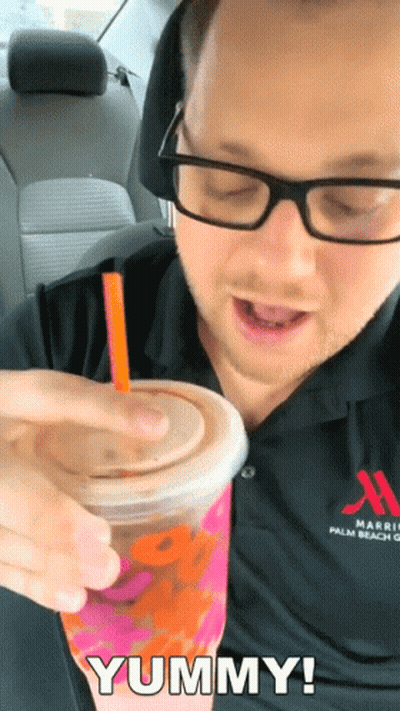 A Man In A Marriott Palm Beach Shirt Is Drinking A Dunkin ' Donuts Drink GIF