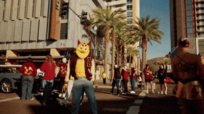 A Man In A Mascot Costume Stands On A Street GIF