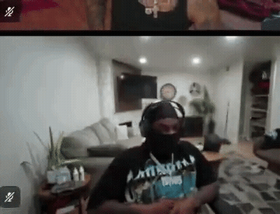 A Man In A Mask And Headphones Is Sitting In A Living Room . GIF