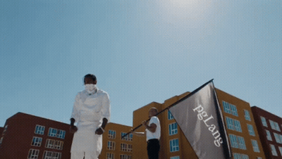 A Man In A Mask Holds A Flag That Says Pg Lane GIF