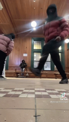 A Man In A Mask Is Dancing In A Room With A Checkered Floor GIF