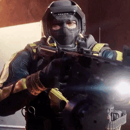A Man In A Mask Is Holding A Gun In His Hand . GIF