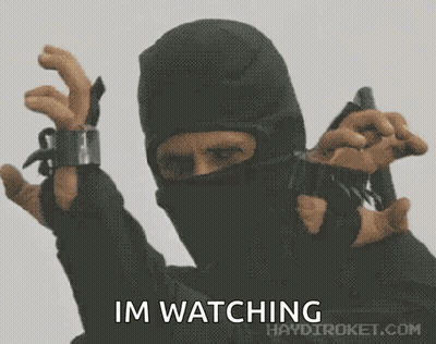 A Man In A Mask Is Holding A Gun With The Words Im Watching Written Below Him GIF