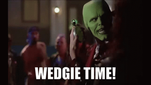 A Man In A Mask Is Holding A Watch In His Hand And Says Wedgie Time . GIF