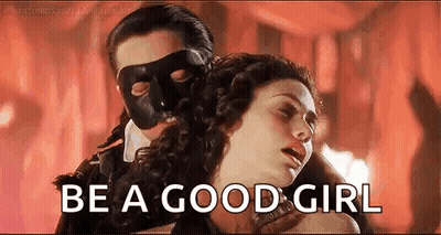 A Man In A Mask Is Holding A Woman In A Room And Says `` Be A Good Girl '' . GIF